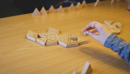 Hand/arm som plockar med ett spel